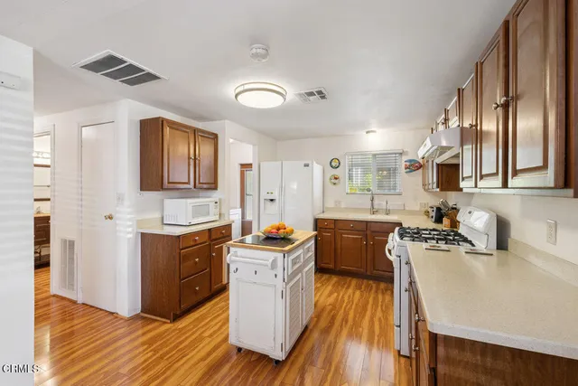 a kitchen with stainless steel appliances granite countertop a sink stove and wooden floor