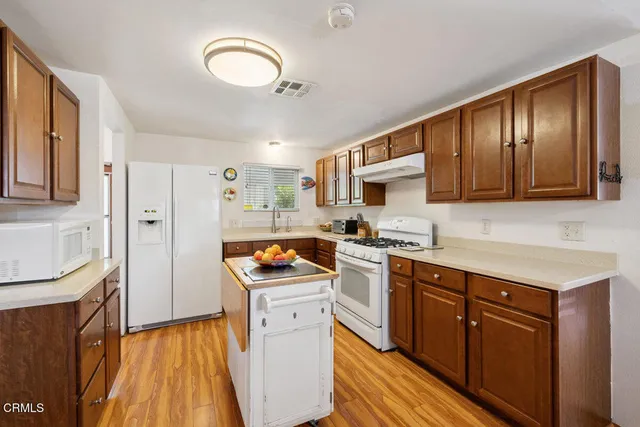 a kitchen with stainless steel appliances granite countertop a stove a sink dishwasher and a refrigerator