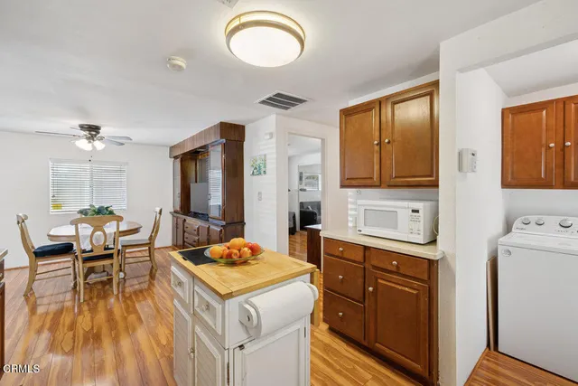 a kitchen with a stove a refrigerator a sink dishwasher with a dining table and chairs