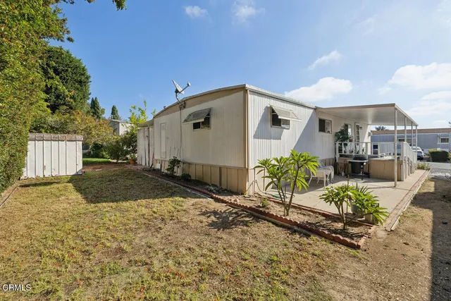 a backyard of a house with a yard and outdoor seating