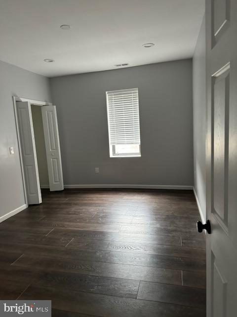 107 West Merchant Street, Unit 2B Audubon, NJ 08106 - Photo 6 of 13 an empty room with wooden floor and windows