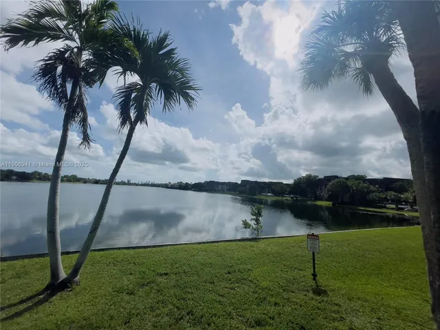a backyard of a house with lots of green space and lake view