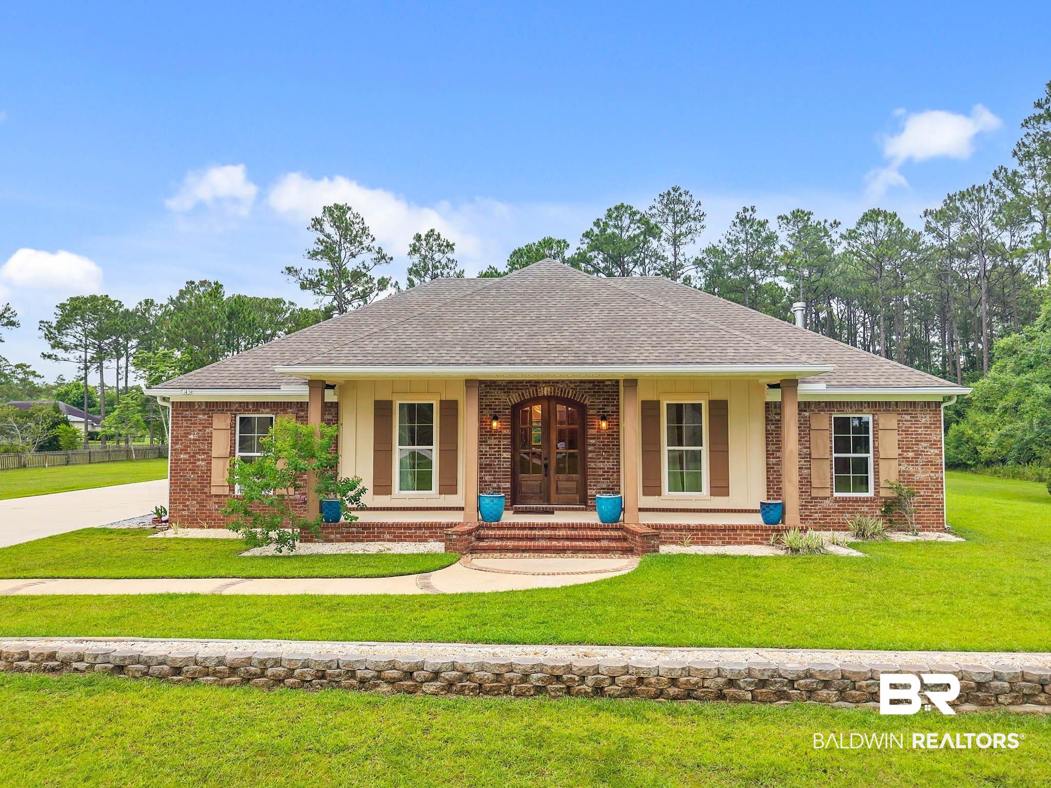 8145 Bay View Drive Foley, AL 36535 - Photo 1 of 81 View of front of property with a porch, a shingled roof, brick siding, and a front lawn
