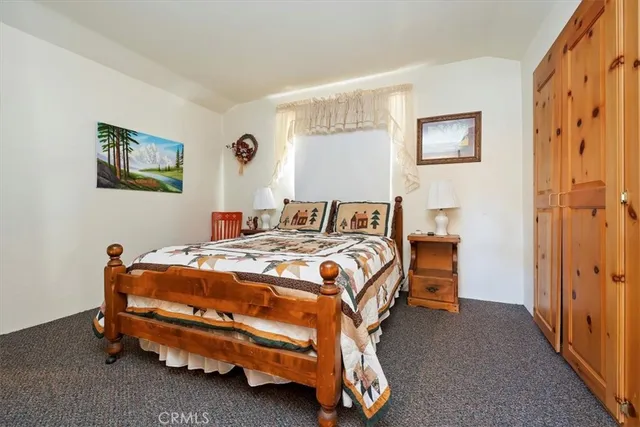 a bedroom with a bed and large windows