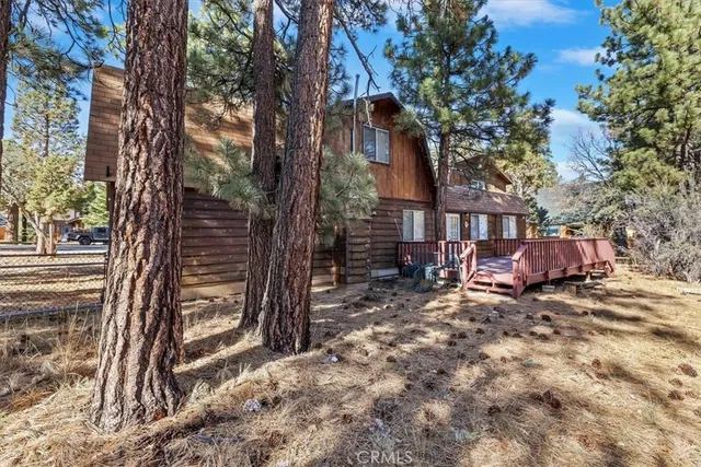 an aerial view of residential house with outdoor space and trees all around