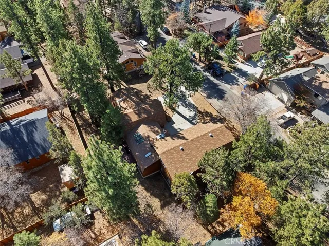 an aerial view of a house with a yard and large tree