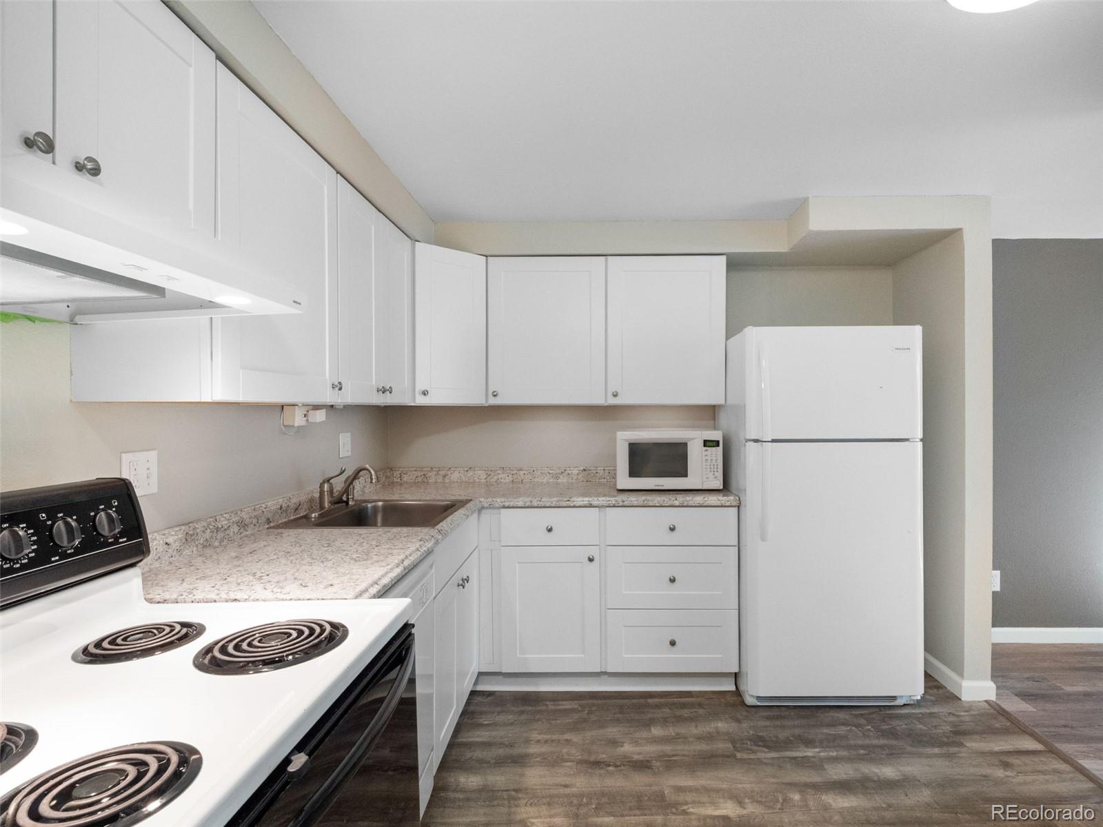 1304 South Parker Road, Unit 146 Denver, CO 80231 - Photo 4 of 22 a kitchen with granite countertop a sink stove and refrigerator