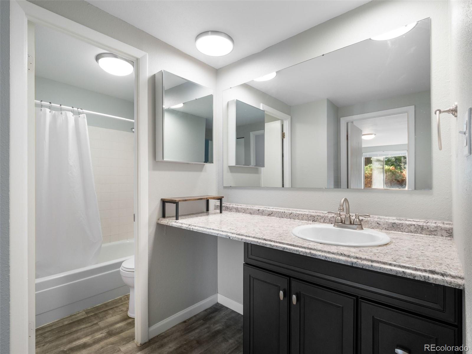 1304 South Parker Road, Unit 146 Denver, CO 80231 - Photo 8 of 22 a bathroom with a granite countertop sink and a mirror
