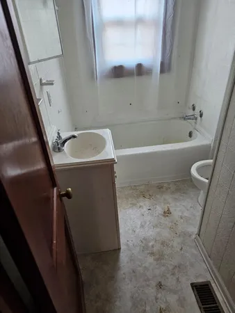 a bathroom with a tub sink and toilet