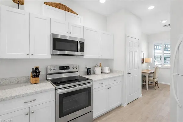 a kitchen with stainless steel appliances a stove a sink a refrigerator a stove a microwave and cabinets