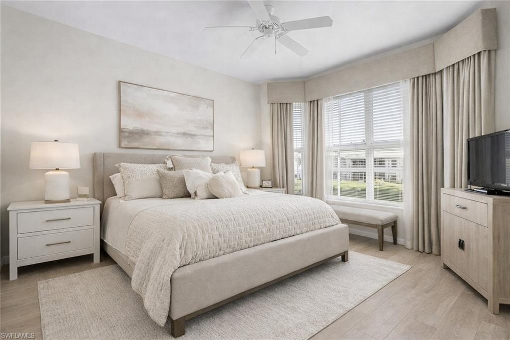 7910 Mahogany Run Lane, Unit 1225 Naples, FL 34113 - Photo 15 of 48 a spacious bedroom with a bed and a flat screen tv