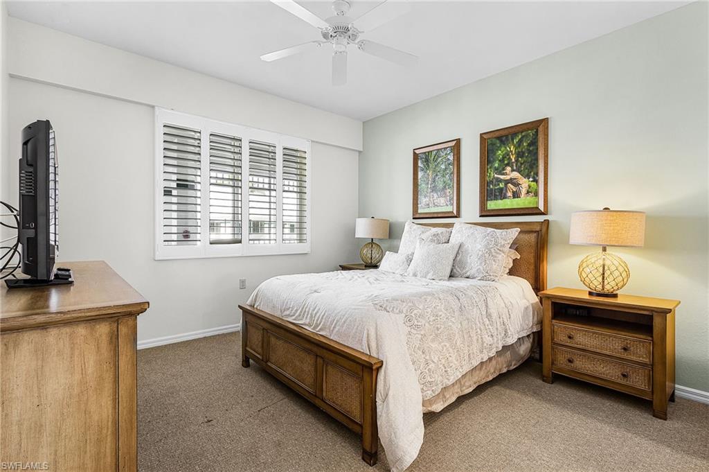 7910 Mahogany Run Lane, Unit 1225 Naples, FL 34113 - Photo 16 of 42 a bedroom with a bed and a flat tv screen on a dresser
