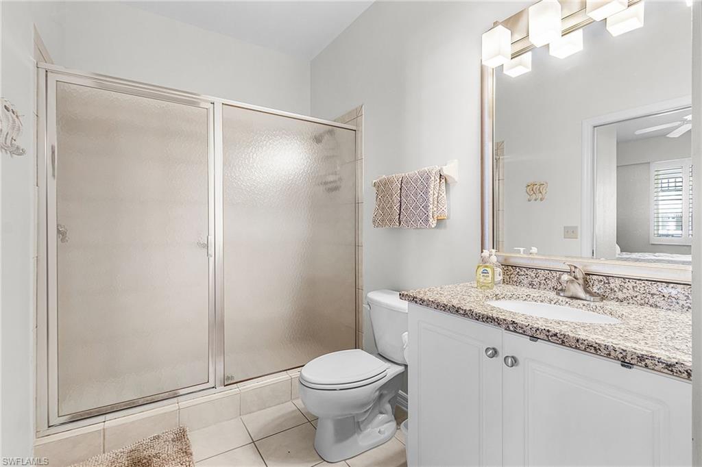 7910 Mahogany Run Lane, Unit 1225 Naples, FL 34113 - Photo 17 of 42 a bathroom with a granite countertop sink toilet and shower