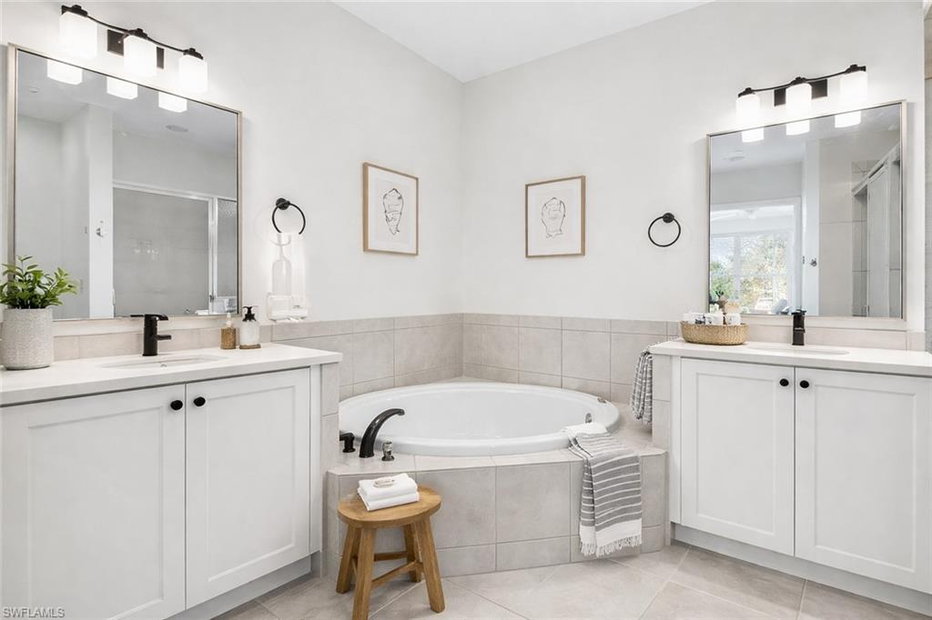 7910 Mahogany Run Lane, Unit 1225 Naples, FL 34113 - Photo 19 of 48 a bathroom with a bathtub a sink a toilet a mirror and vanity