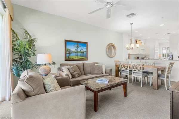 a living room with furniture and a chandelier