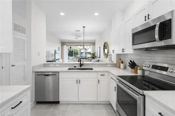 a kitchen with stainless steel appliances white cabinets and white appliances