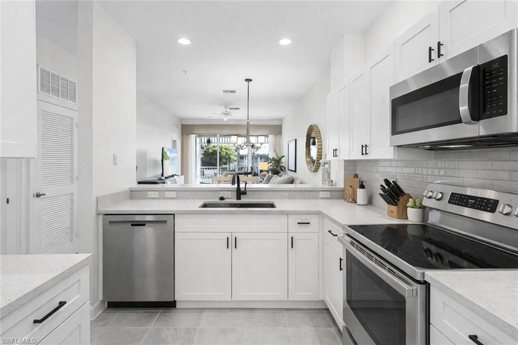 7910 Mahogany Run Lane, Unit 1225 Naples, FL 34113 - Photo 9 of 48 a kitchen with a sink stove and microwave
