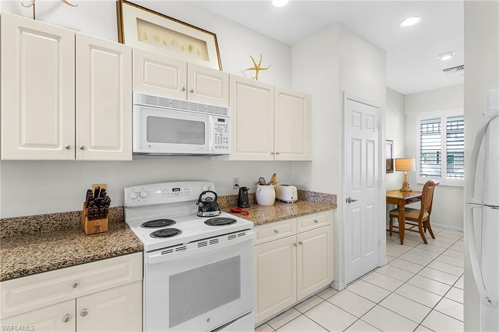 7910 Mahogany Run Lane, Unit 1225 Naples, FL 34113 - Photo 9 of 42 a kitchen with stainless steel appliances granite countertop a sink and cabinets