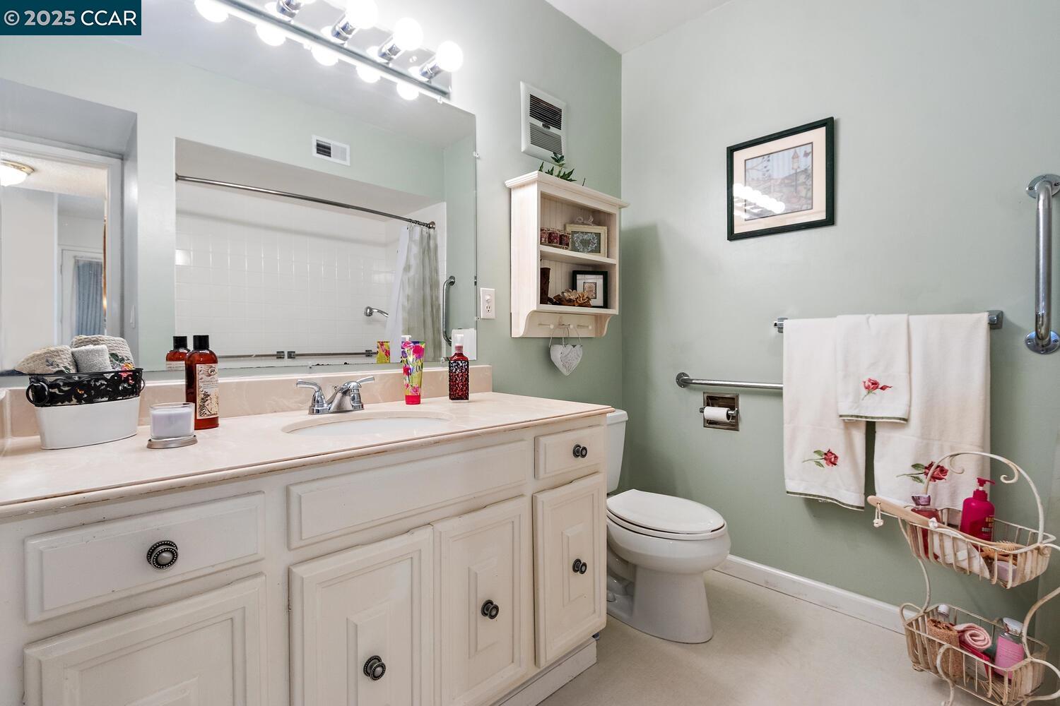 2709 Golden Rain Road, Unit 6 Walnut Creek, CA 94595 - Photo 17 of 46 a bathroom with a sink a toilet and a mirror