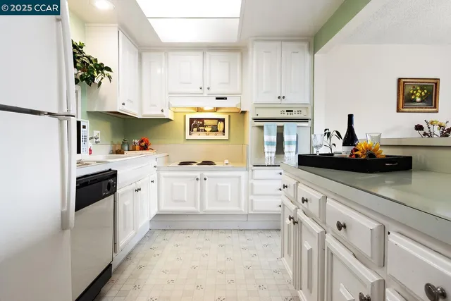 a kitchen with white cabinets and white appliances