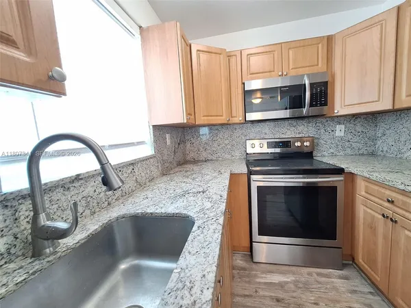 a kitchen with granite countertop a stove and a sink