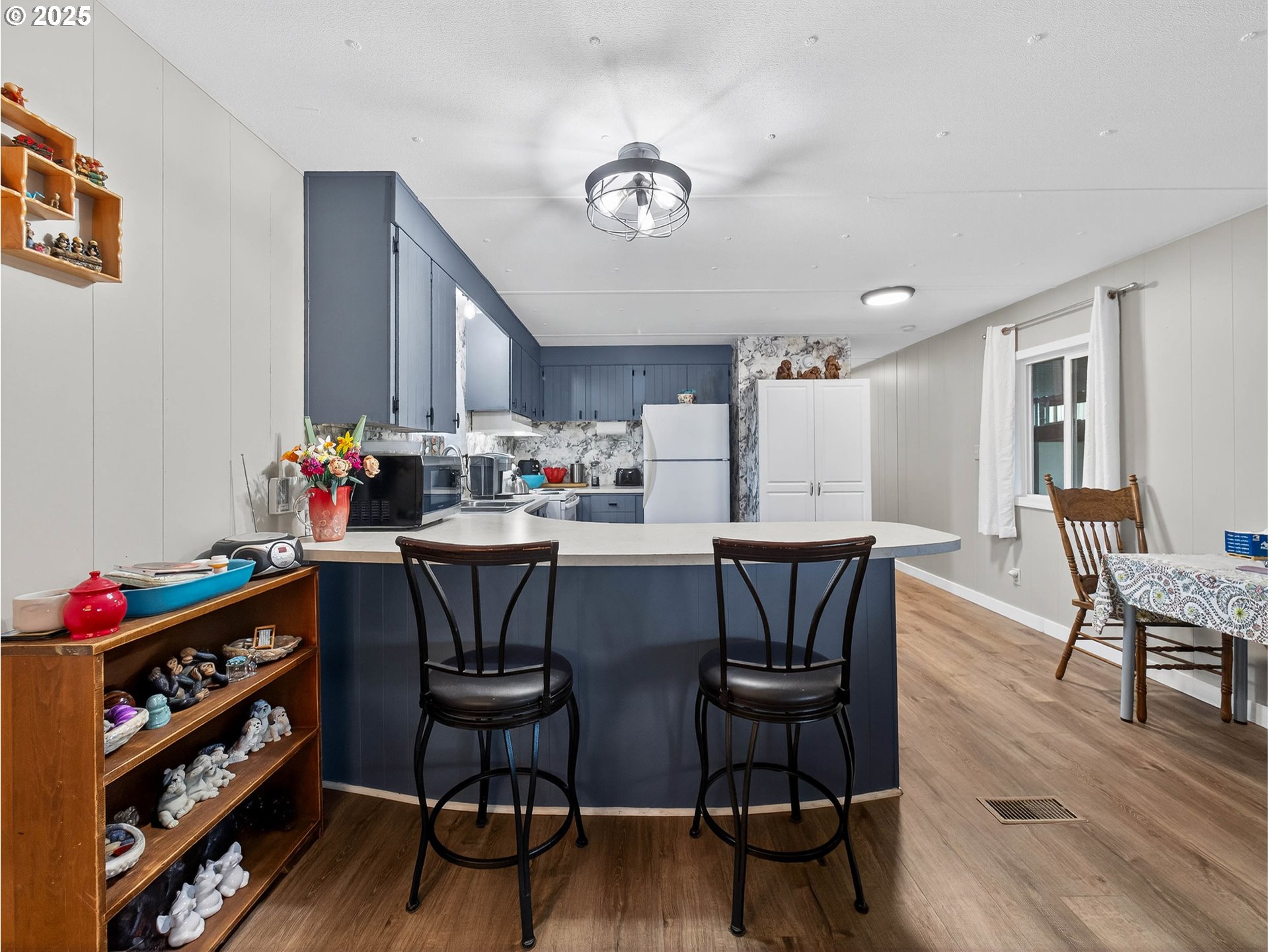 2902 East 2nd Street, Unit 54 Newberg, OR 97132 - Photo 13 of 32 a kitchen with stainless steel appliances a dining table chairs and wooden floor