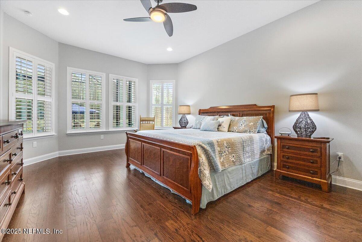 80 Greenview Lane St. Augustine, FL 32092 - Photo 17 of 37 a bedroom with a large bed a chandelier and a large window