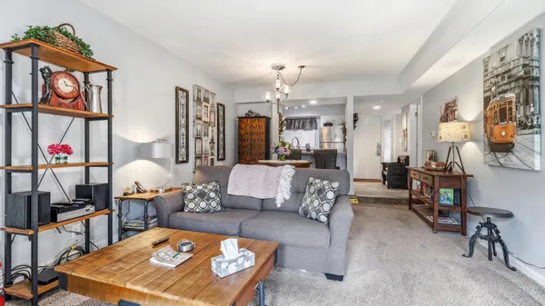a living room with furniture a chandelier and a table