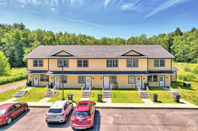 a aerial view of a house with swimming pool lawn chairs and a fire pit
