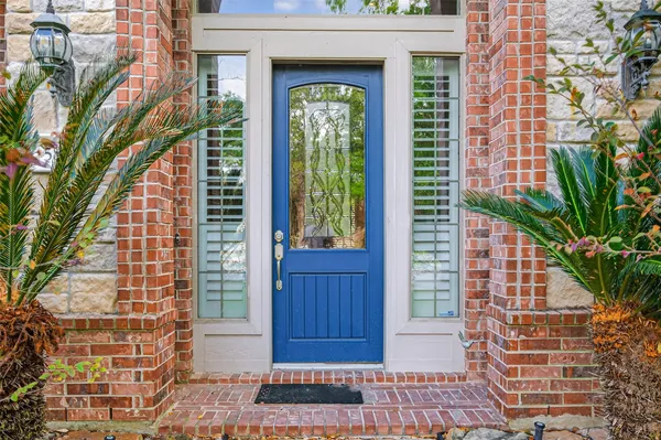 a view of a brick house with a windows and plants