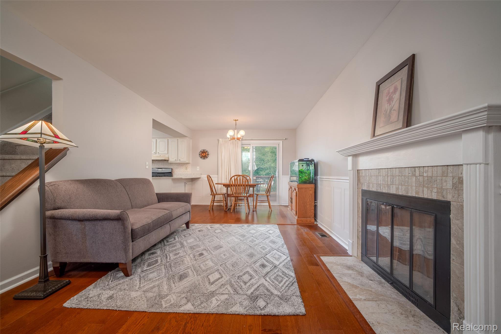 22533 Winfield Road Novi, MI 48375 - Photo 11 of 43 Living area featuring a fireplace with a tile surround and white mantel, wood-finish flooring, and white wall paneling