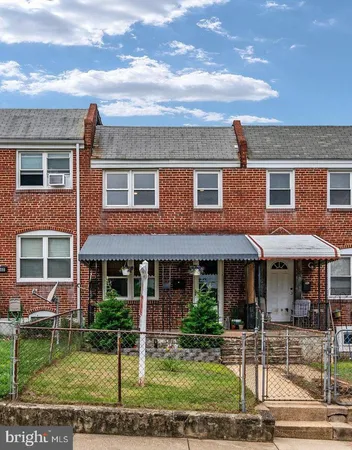 front view of a brick house with a yard