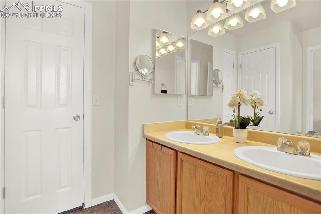 1776 Reilly Grove Colorado Springs, CO 80951 - Photo 15 of 21 a bathroom with a sink vanity and a mirror