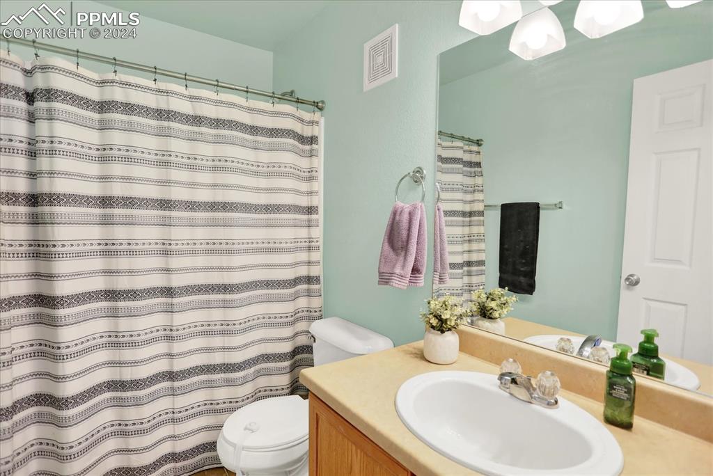 1776 Reilly Grove Colorado Springs, CO 80951 - Photo 18 of 21 a bathroom with a sink a toilet and shower curtain