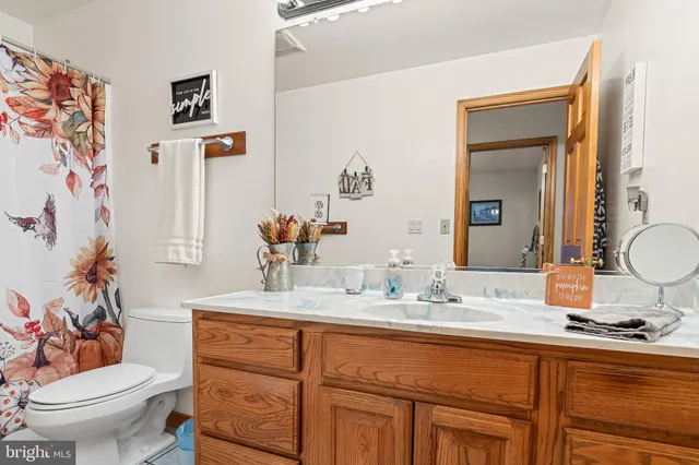 a bathroom with a granite countertop sink mirror vanity and toilet