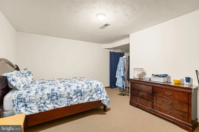a bedroom with a bed and dresser with mirror