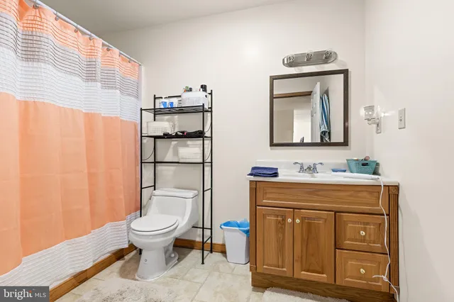 a bathroom with a toilet a sink and mirror
