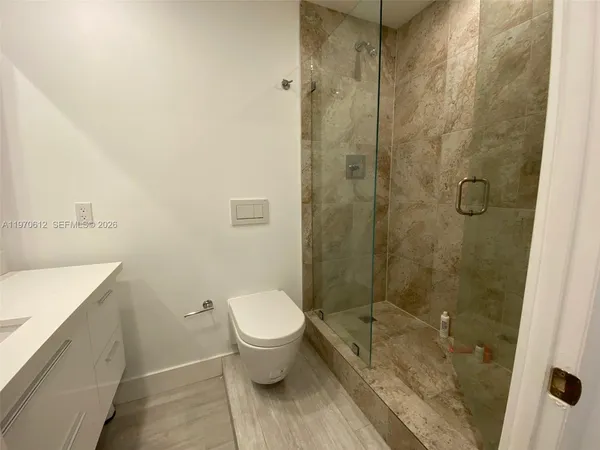 a bathroom with a granite countertop sink toilet and shower