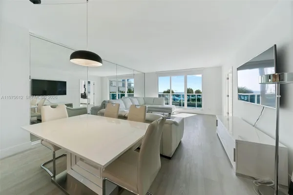 a living room with furniture a flat screen tv and a chandelier