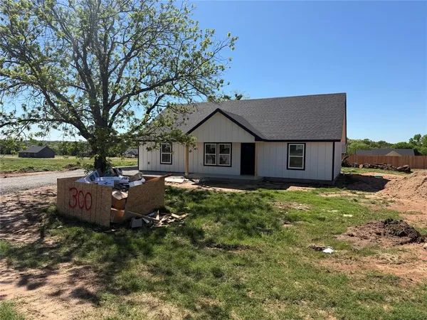 a view of a house with a backyard and a tree