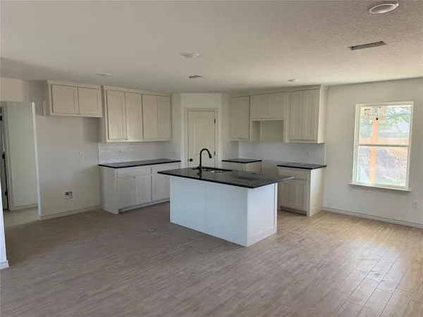 a kitchen with granite countertop white cabinets and white appliances
