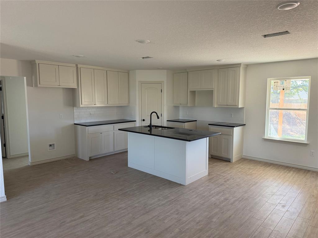 300 Myers Drive Springtown, TX 76082 - Photo 3 of 8 a kitchen with granite countertop white cabinets and white appliances