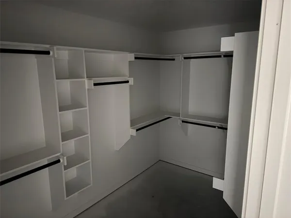 a view of walk in closet with empty racks