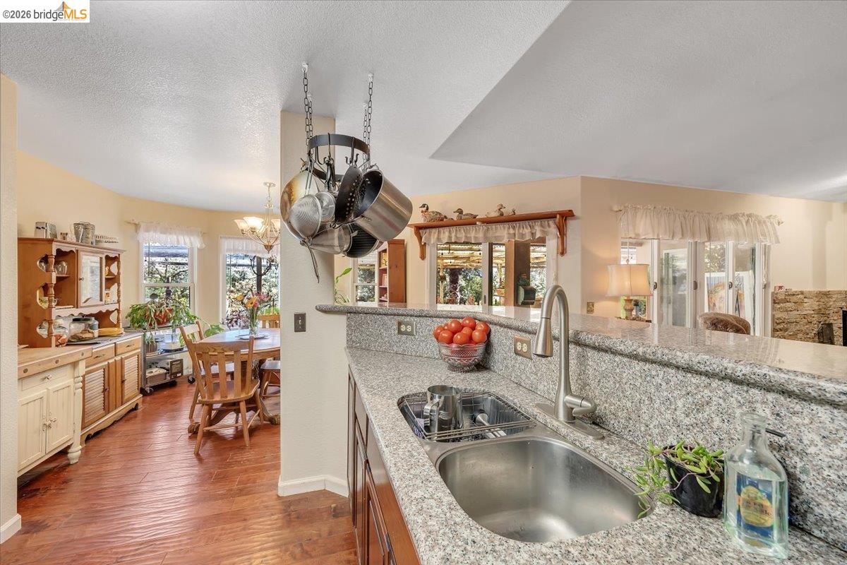 14450 Jacksonville Road Jamestown, CA 95327 - Photo 24 of 85 Kitchen featuring granite countertops, stainless steel sink, and wood-finish flooring