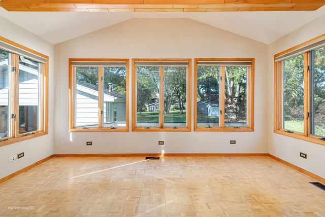 a view of an empty room with a window and kitchen area