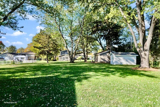 a view of a house with a big yard and large trees