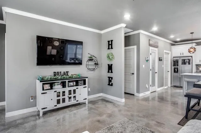 a kitchen with stainless steel appliances kitchen island granite countertop a refrigerator and a dining table