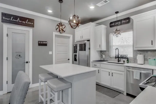 a kitchen with stainless steel appliances a stove a sink a microwave and cabinets