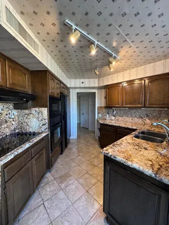 a kitchen with stainless steel appliances granite countertop a sink stove and cabinets