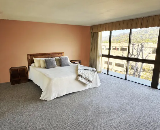 a bed room with a bed and a large window